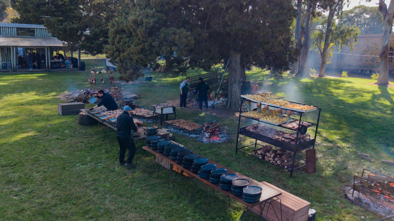 Equipo gastronómico trabajando en estaciones de cocina al aire libre